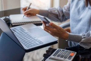 Woman using a phone and a calculator